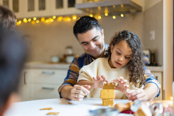 chica haciendo galletas navideñas de jengibre con un padre - christmas child cookie table fotografías e imágenes de stock