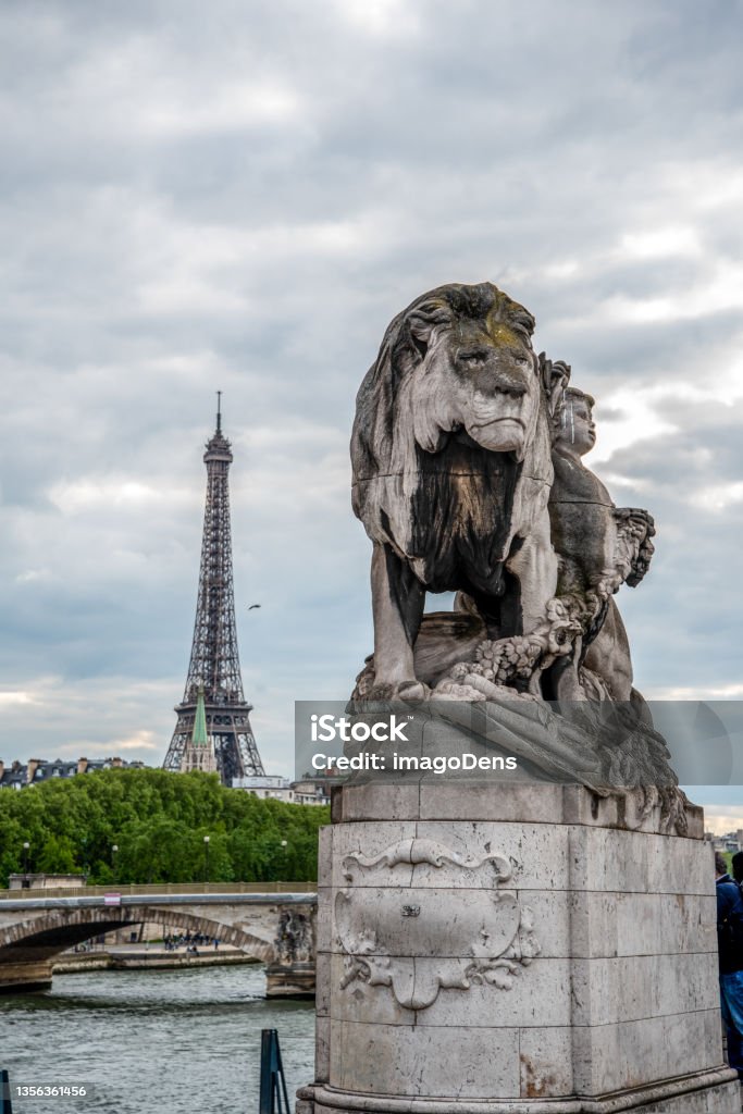 Statue of a Lioin on Bridge Alexandre III, view to Eiffel tower, Paris Statue of a Lioin on Bridge Alexandre III, view to Eiffel tower, Paris, France Architecture Stock Photo