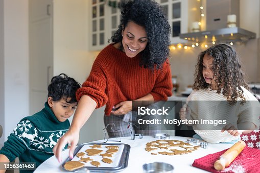 istock Sister and brother making Christmas gingerbread cookies with a mother 1356361463