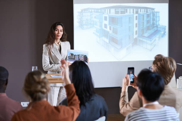 istock Businesswoman presenting modern building at seminar 1356362563