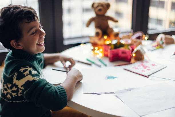 istock Boy drawing a Christmas wish list 1356362647