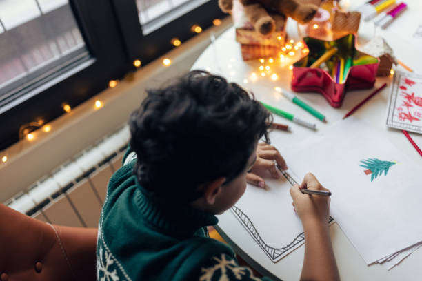 istock Boy drawing a Christmas wish list 1356362709