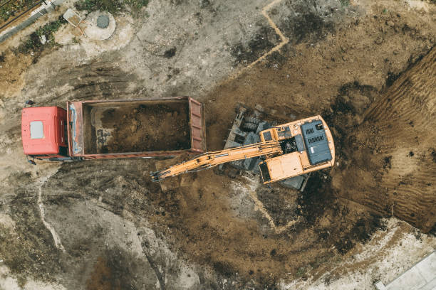 istock Excavator digs pit foundation. Earthwork in excavation in construction site, aerial top view 1356363083