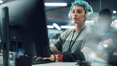 In Diverse Office: Portrait of Young Stylish Woman Working on Desktop Computer. Colorful Girl Creating Modern Content, Project Design, Marketing Strategy. Uses Headphones to Listen to Podcast, Music