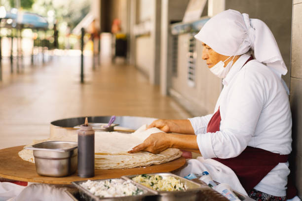 Turkish Woman making Tortillas on a wooden rustic table.
