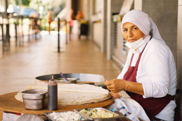 Turkish Woman making Tortillas on a wooden rustic table.