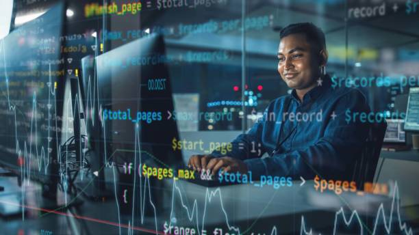 istock Concept Shot with Visualisation of Running Computer Code on Foreground. Portrait of Handsome Indian Man in Working on Computer at Night in Office. Digital Entrepreneur Creating Modern Software. 1356364202