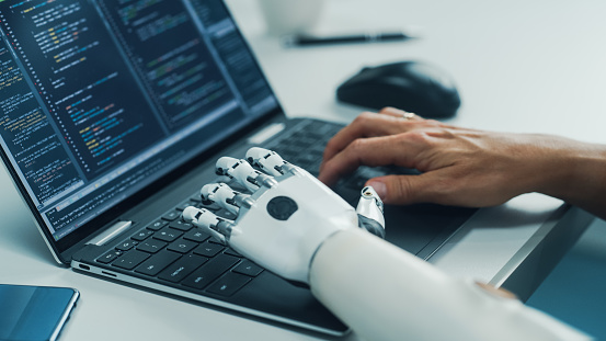 Close-up on Hands: Programmer With Disability Using Prosthetic Arm to Work on Laptop Computer. Specialist Swift and Natural Use of Myoelectric Bionic Hand To Type Code for Software