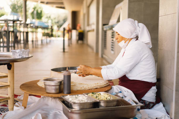 Turkish Woman making Tortillas on a wooden rustic table.