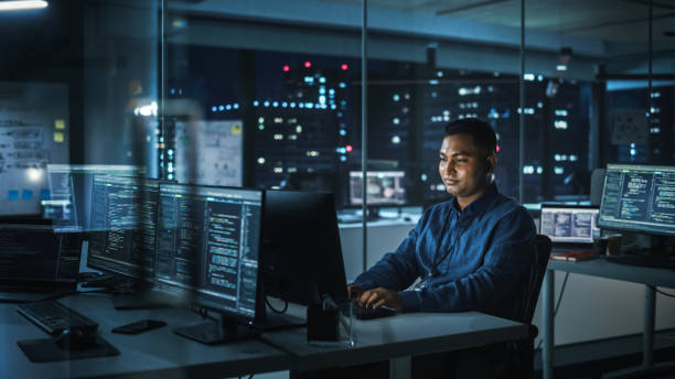 istock Night Office: Portrait of Handsome Indian Man in Working on Desktop Computer. Digital Entrepreneur Typing, Creating Modern Software, e-Commerce App Design, Programming. Stylish Authentic Person 1356364332
