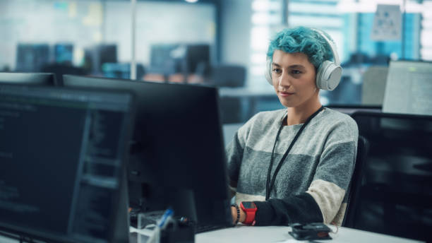 istock In Diverse Office: Young Stylish Woman in Headphones Working on Desktop Computer. Digital Entrepreneur Creating Modern Content, Colorful e-Commerce Project Design, e-Business Social Media Strategy 1356364351