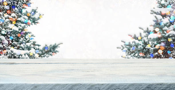 istock Wood table top on  christmas tree background 1356364363