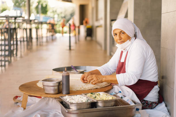 Turkish Woman making Tortillas on a wooden rustic table.