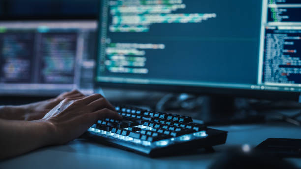 istock Close-up Focus on Person's Hands Typing on the Desktop Computer Backlit Keyboard. Screens Show Coding Language User Interface. Software Engineer Create Innovative e-Commerce App. Program Development 1356364376