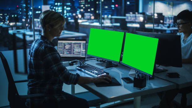 istock Night Office: Person with Disability Using Prosthetic Arm to Work on Green Screen Chroma Key Computer. Swift and Natural Use of Myoelectric Bionic Hand To Type Code for Software at Night. 1356364388