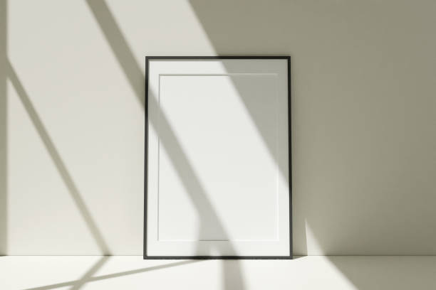 istock Vertical black photo frames mockup on the floor leaning against the room wall with shadow. 3D Rendering. 1356366016