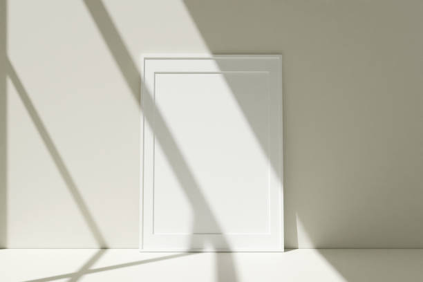 istock Vertical white photo frames mockup on the floor leaning against the room wall with shadow. 3D Rendering. 1356366025