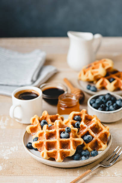 istock Belgian waffles with blueberries and cup of coffee 1356368912