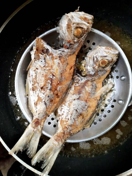 istock Frying 2 Milkfish in cooking pan - food preparation. 1356369016