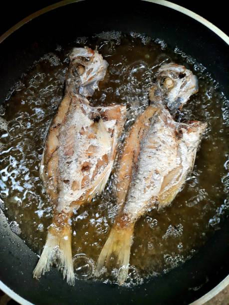 istock Frying 2 Milkfish in cooking pan - food preparation. 1356369033