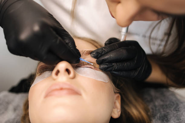 istock Woman doing eyelashes lamination in beauty studio. Blond hair model has staining, curling, laminating and extension for lashes 1356370040