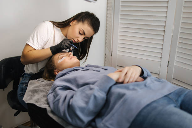 istock Beautician making eyelash lamination procedures for young model. Modern eyelash care procedures laminating and extension for lashes. Professional beauty studio 1356370306