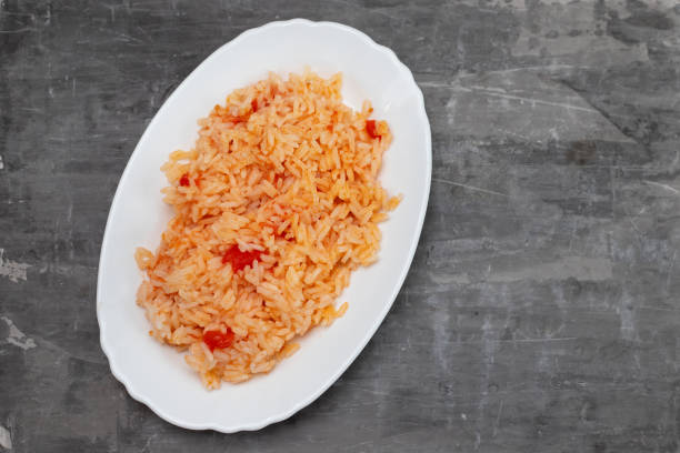 istock boiled rice with tomato and spices on white dish 1356370452