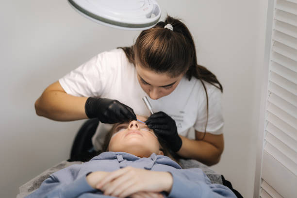 istock Beautician making eyelash lamination procedures for young model. Modern eyelash care procedures laminating and extension for lashes. Professional beauty studio 1356370627