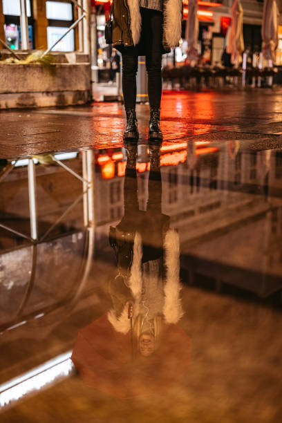 istock Woman in boots standing in puddle 1356371003