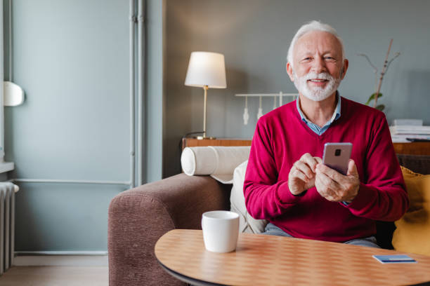 istock Senior man is using mobile phone at home 1356371835