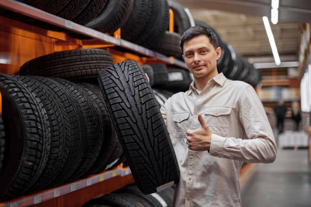 male customer taking new tires in the supermarket. - adult variation boutique occupation imagens e fotografias de stock