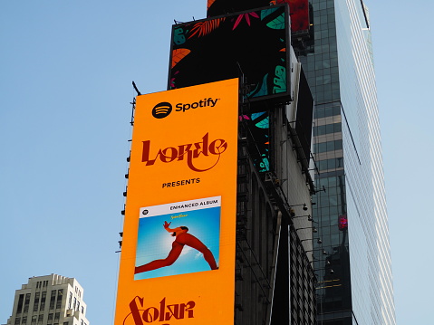 New York City, New York United States - August 29 2021: Spotify Lorde popstar yellow billboard music album advertisement in Times Square with logo.