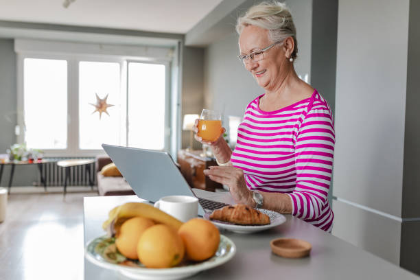 istock Senior woman using laptop at home on the kitchen counter 1356372458