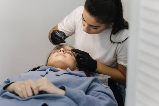 istock Beautician making eyelash lamination procedures for young model. Modern eyelash care procedures laminating and extension for lashes. Professional beauty studio 1356372578