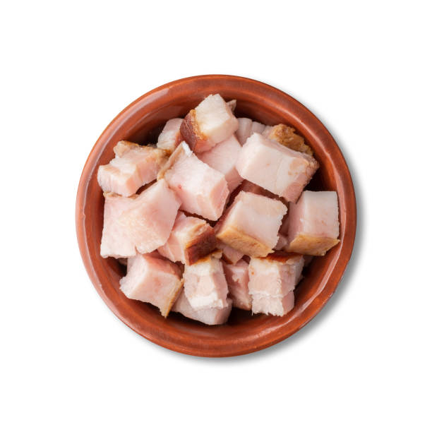 istock Smoked bacon cubes in a bowl isolated over white background 1356374411
