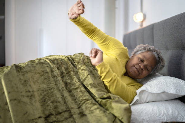 donna anziana che si sveglia a casa - wake up stretching women black foto e immagini stock