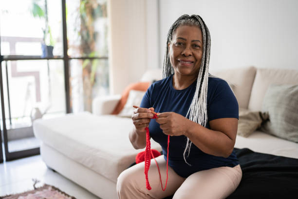 Portrait of a senior woman knitting at home Portrait of a senior woman knitting at home Crochet stock pictures, royalty-free photos & images