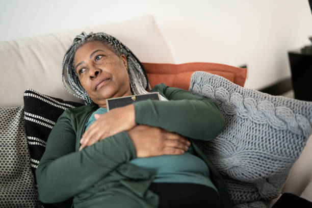 istock Senior woman holding a picture frame missing someone at home 1356378257