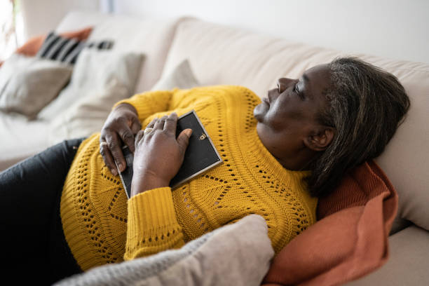 istock Senior woman holding a picture frame missing someone at home 1356378300
