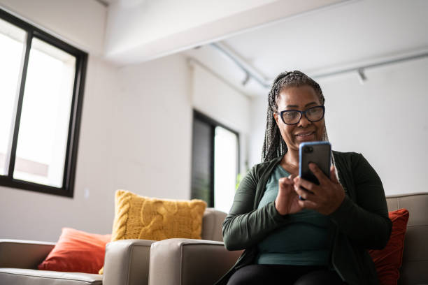 istock Senior woman using a mobile phone at home 1356378451