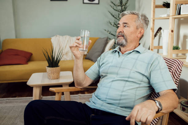 istock Senior man relaxing in a chair and drinking water 1356378995