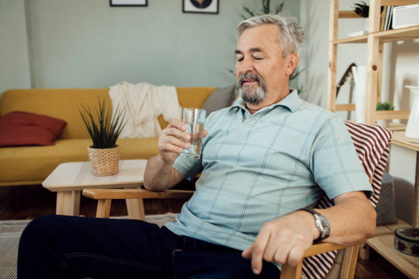 istock Happy mature man refreshing with water at home 1356378996