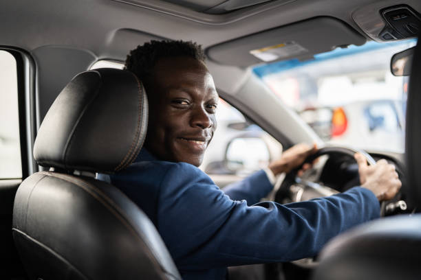 porträt eines jungen mannes, der sich im autohaus für ein neues auto entscheidet - taxifahrer stock-fotos und bilder