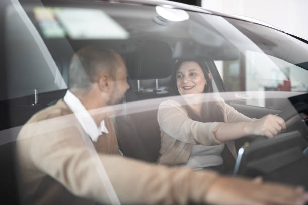 istock Mature couple examining a car before buying 1356380271