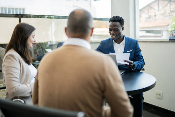 istock Car salesman or finance advisor talking to clients 1356380273