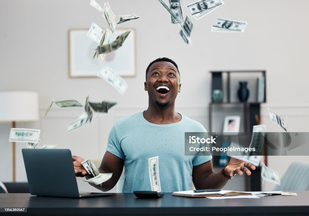 Shot of a young businessman managing his money at home It's raining money! Paper Currency Stock Photo