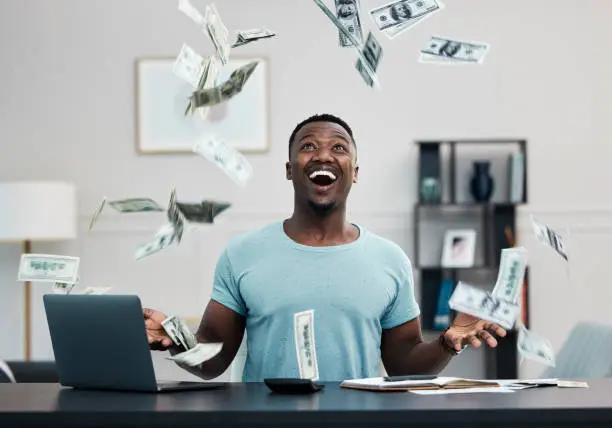 Photo of Shot of a young businessman managing his money at home