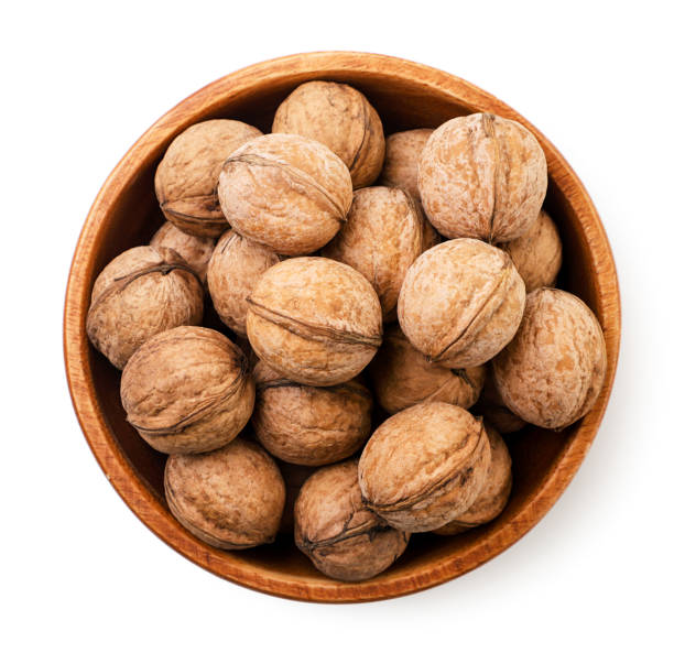 istock Walnuts in a wooden plate on a white background. Top view 1356384090