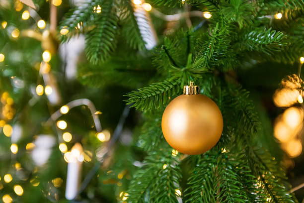 istock Golden Christmas ball on a tree with a garland. 1356385343