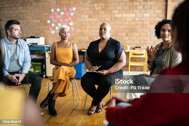 Mid Adult Woman Talking In A Meeting Or Group Therapy Stock Photo - Download Image Now